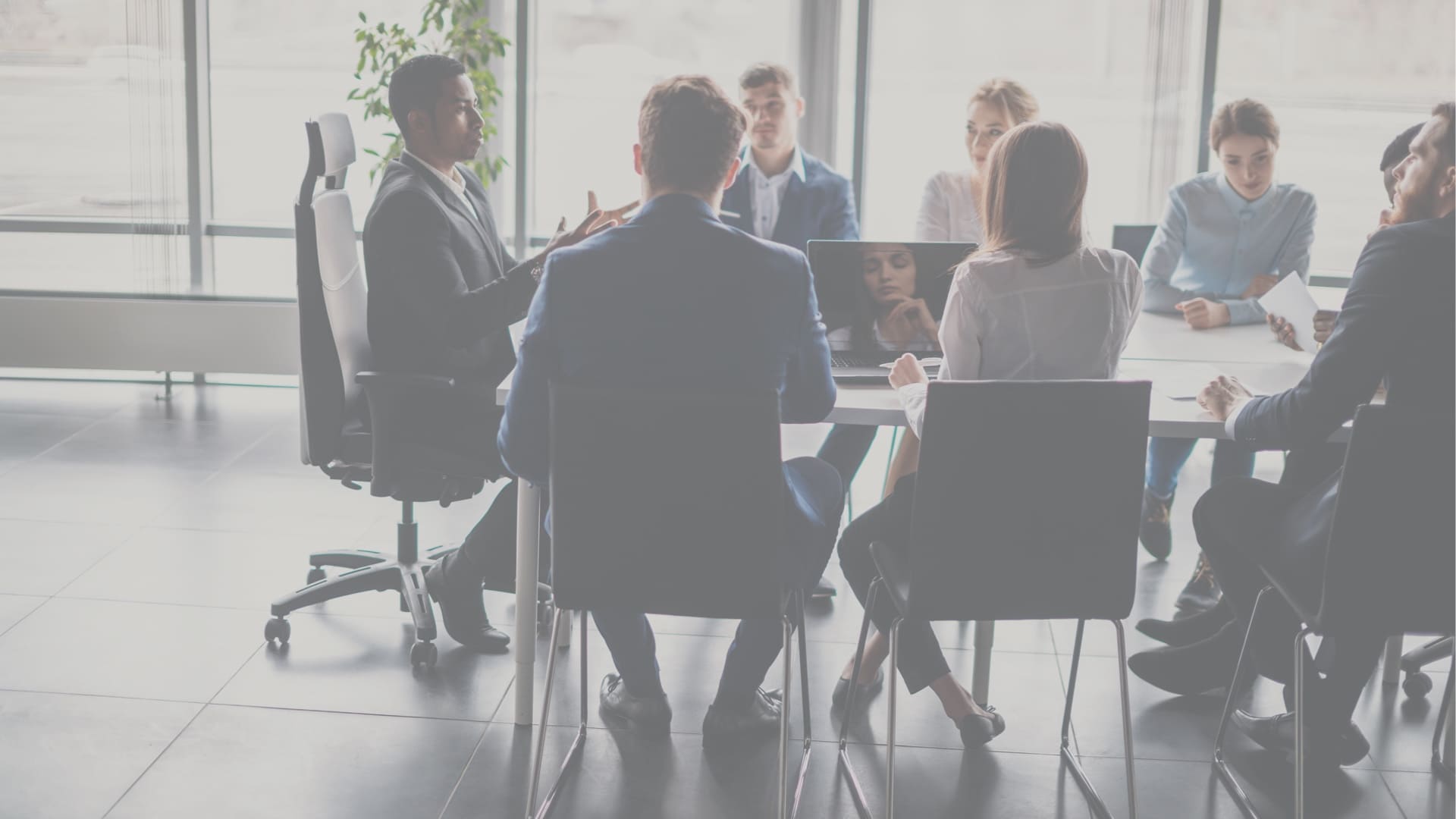 Image of a business team meeting in a room with glass panels